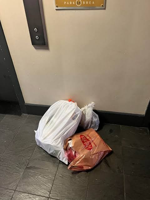 Loose bags on the floor by the elevator near unit 6-6205